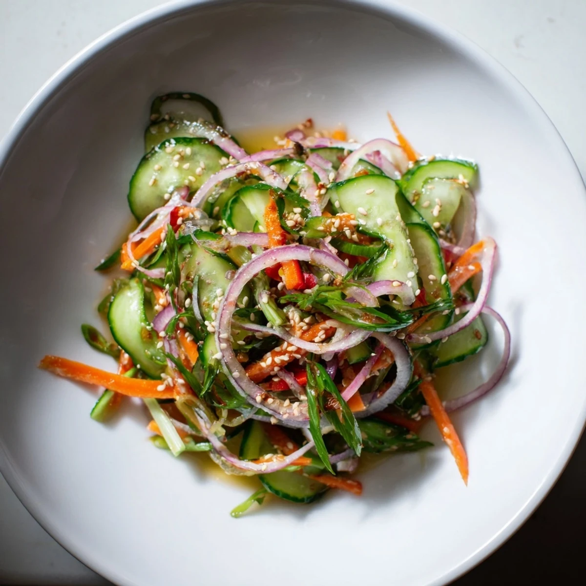 Crisp cucumber salad remix garnished with toasted sesame seeds, perfect as a light appetizer.