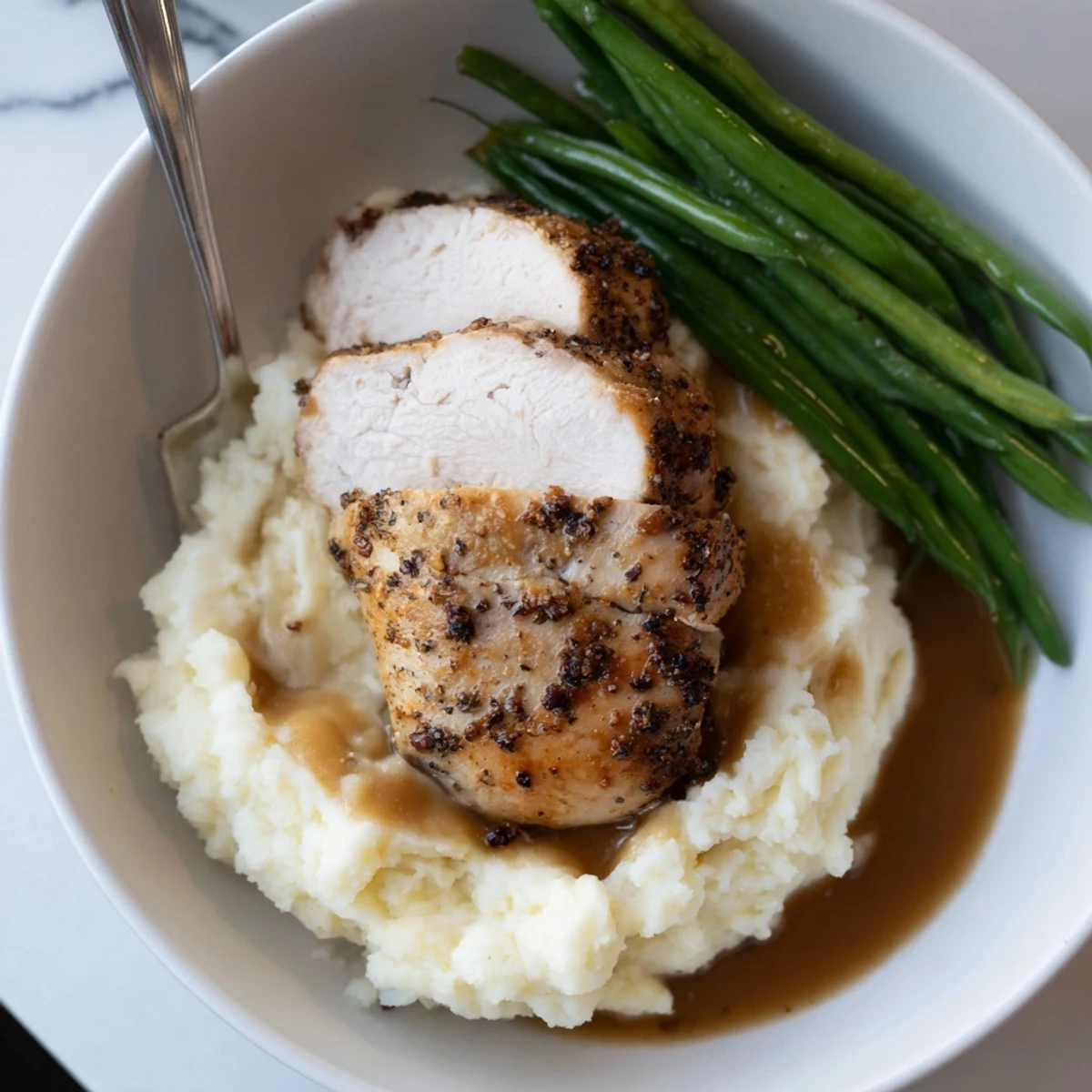 Comforting Pork Chops & Cheddar Mash Bowl served with vibrant, crisp green beans.  