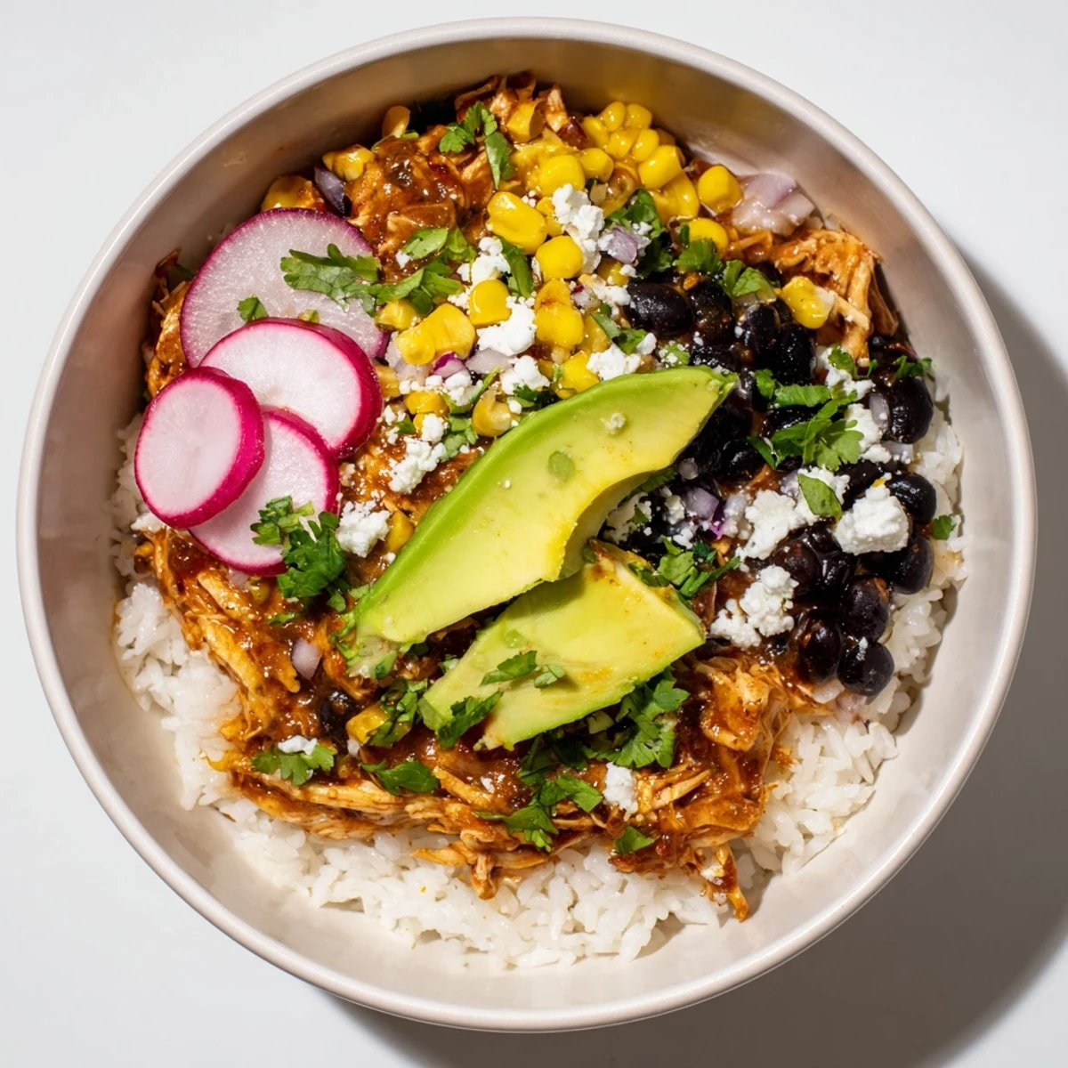 Vibrant Green Enchiladas Rice Bowl overflowing with chicken, rice, beans, and fresh toppings, ready to eat!