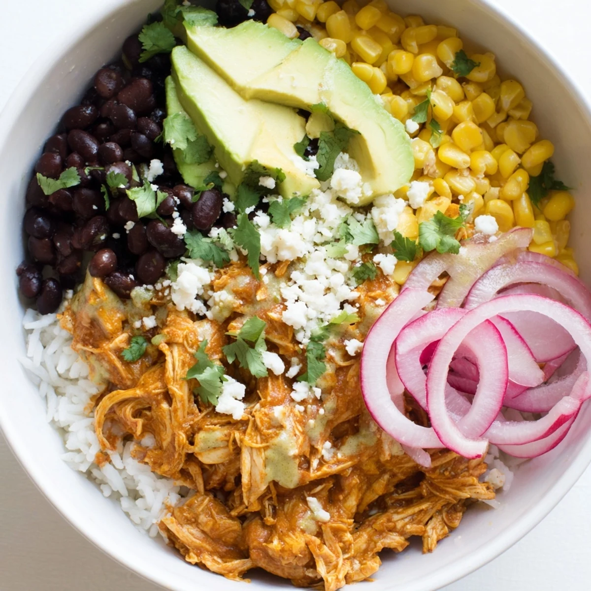 Close-up of a colorful Green Enchiladas Rice Bowl with avocado and cilantro, a flavorful Tex-Mex delight.