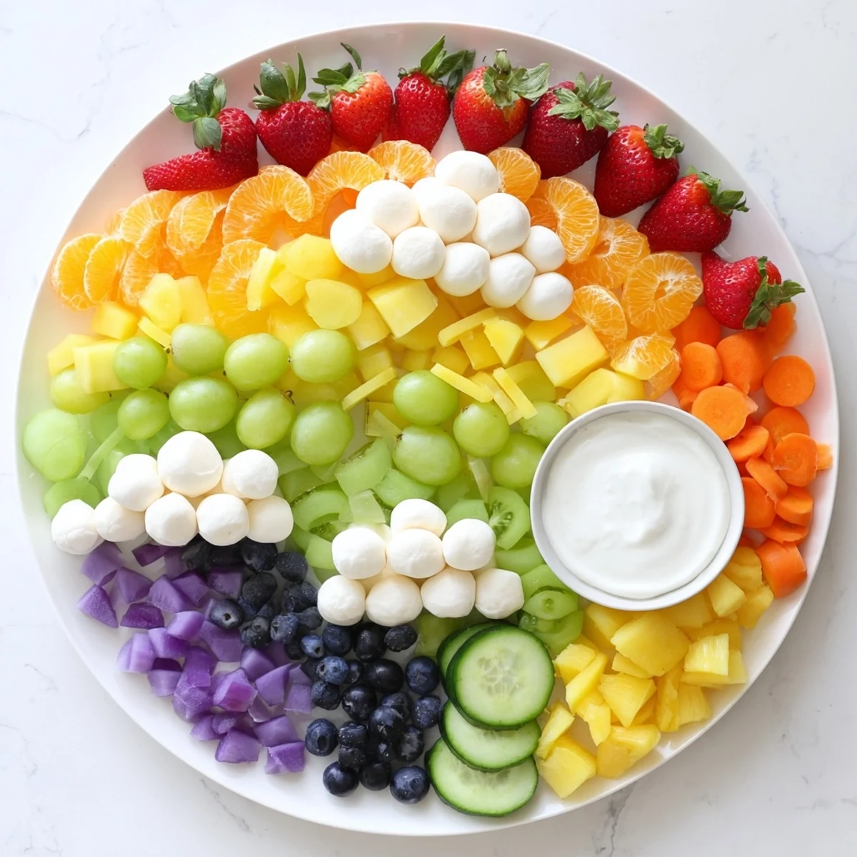A beautiful Rainbow Cloud Snack Board: colorful fruit arranged in a fun, healthy party appetizer.