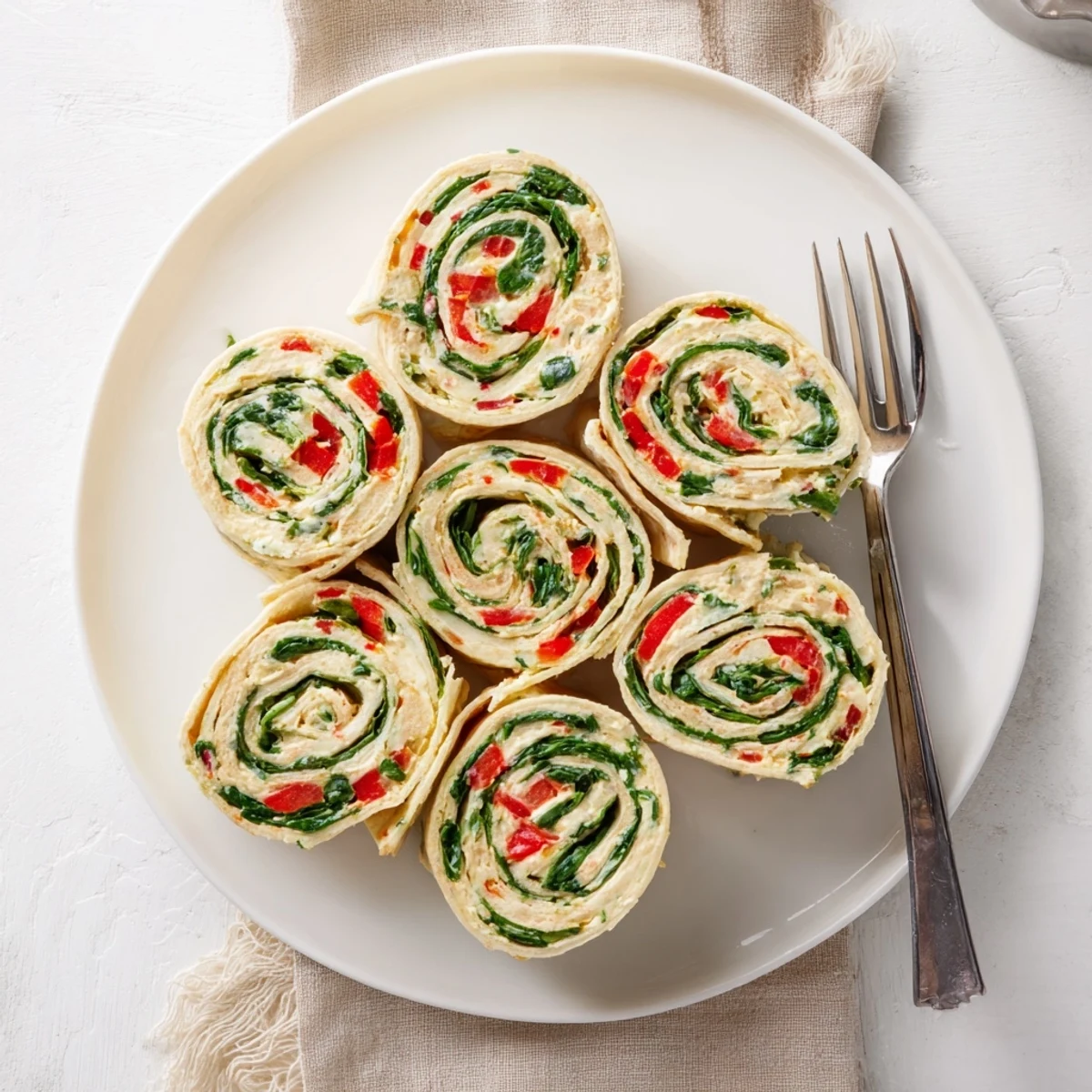 Vibrant Christmas Scarf Tortilla Roll-Ups, showcasing colorful spirals of cream cheese and fresh vegetables.