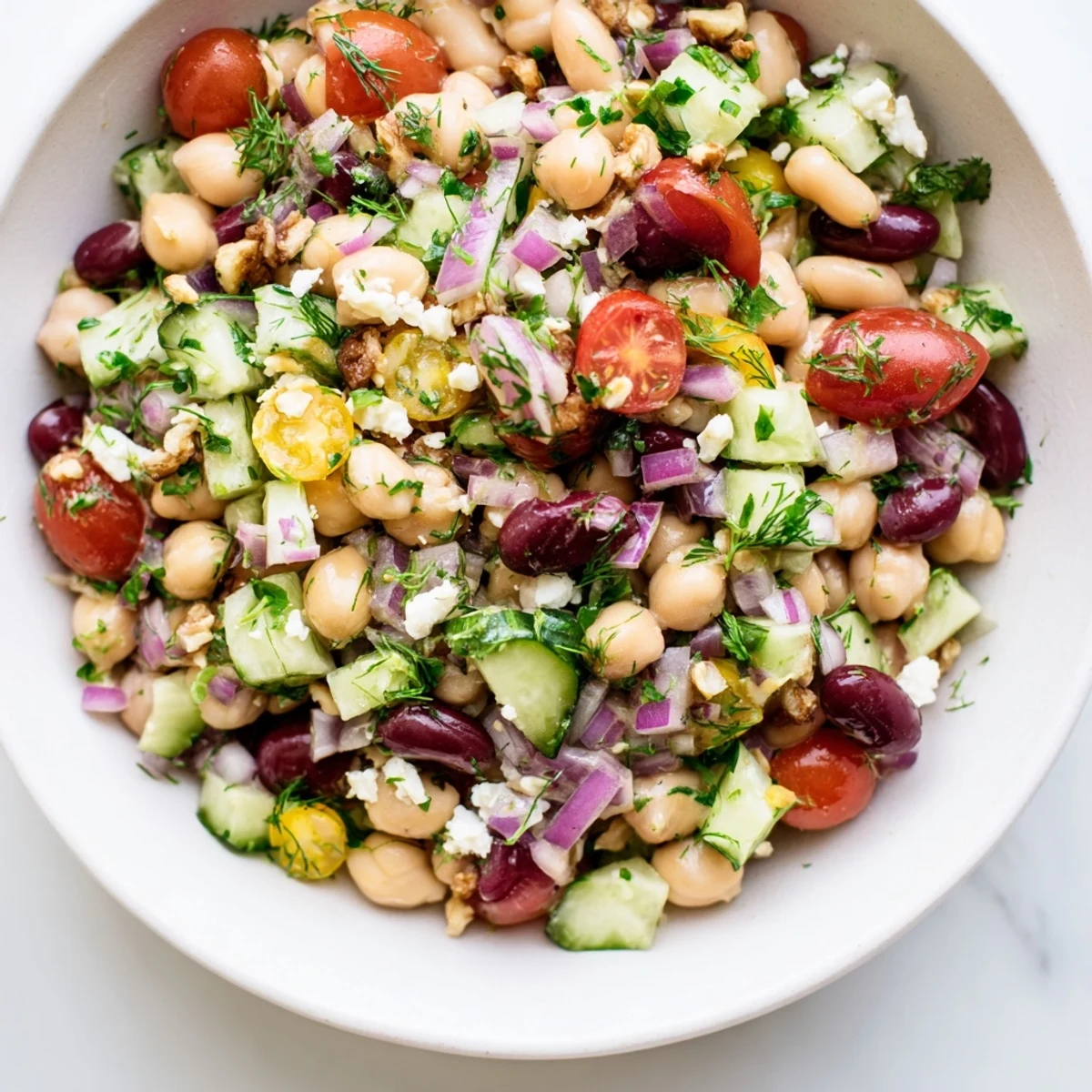 A close-up shot of a healthy bowl of Dense Bean Salad, featuring mixed vegetables and tart cherry dressing.