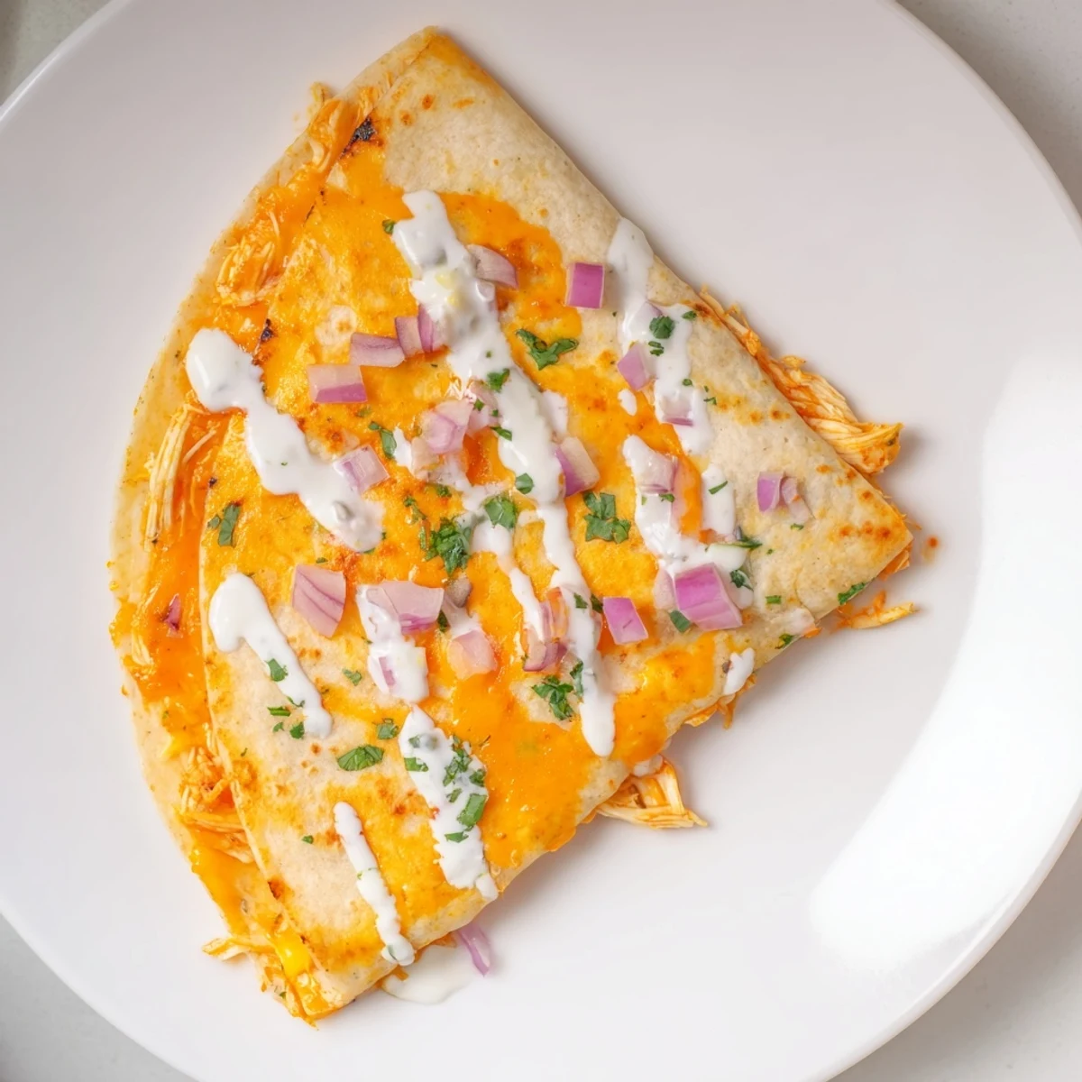 Golden-brown Buffalo Chicken Quesadilla, oozing melted cheese and spicy chicken filling, ready to serve.