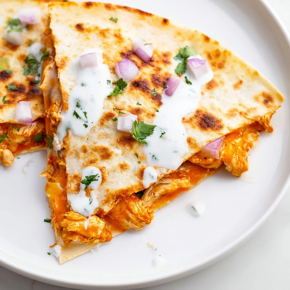 Warm, cheesy Buffalo Chicken Quesadilla wedges, served with ranch dressing, perfect for sharing and dipping.