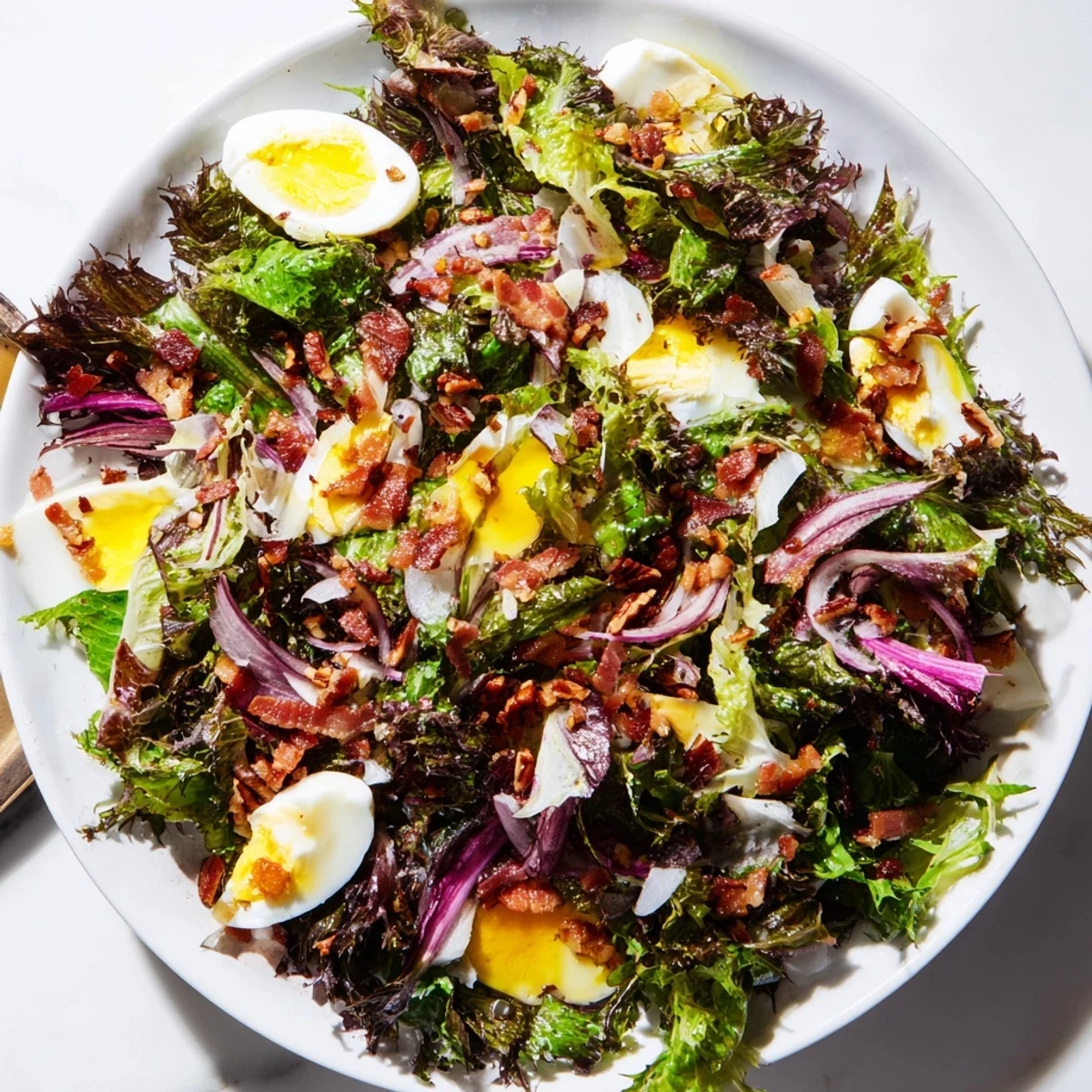 This Bitter Greens Salad with Warm Bacon Dressing features wilted greens, crispy bacon, and a savory vinaigrette.