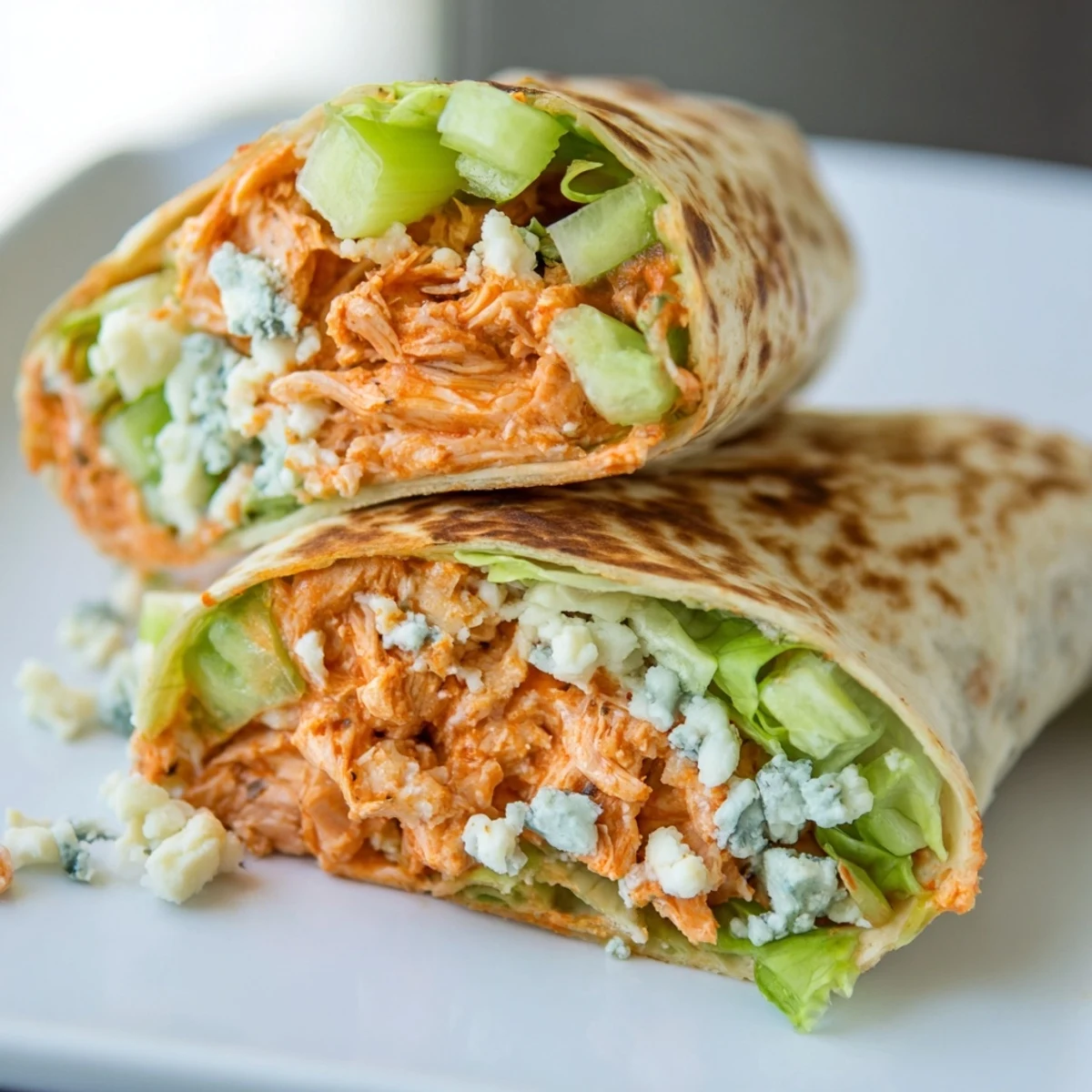 A close-up shot of a flavorful Buffalo Chicken Dip Wrap, ready to eat with a side of ranch.