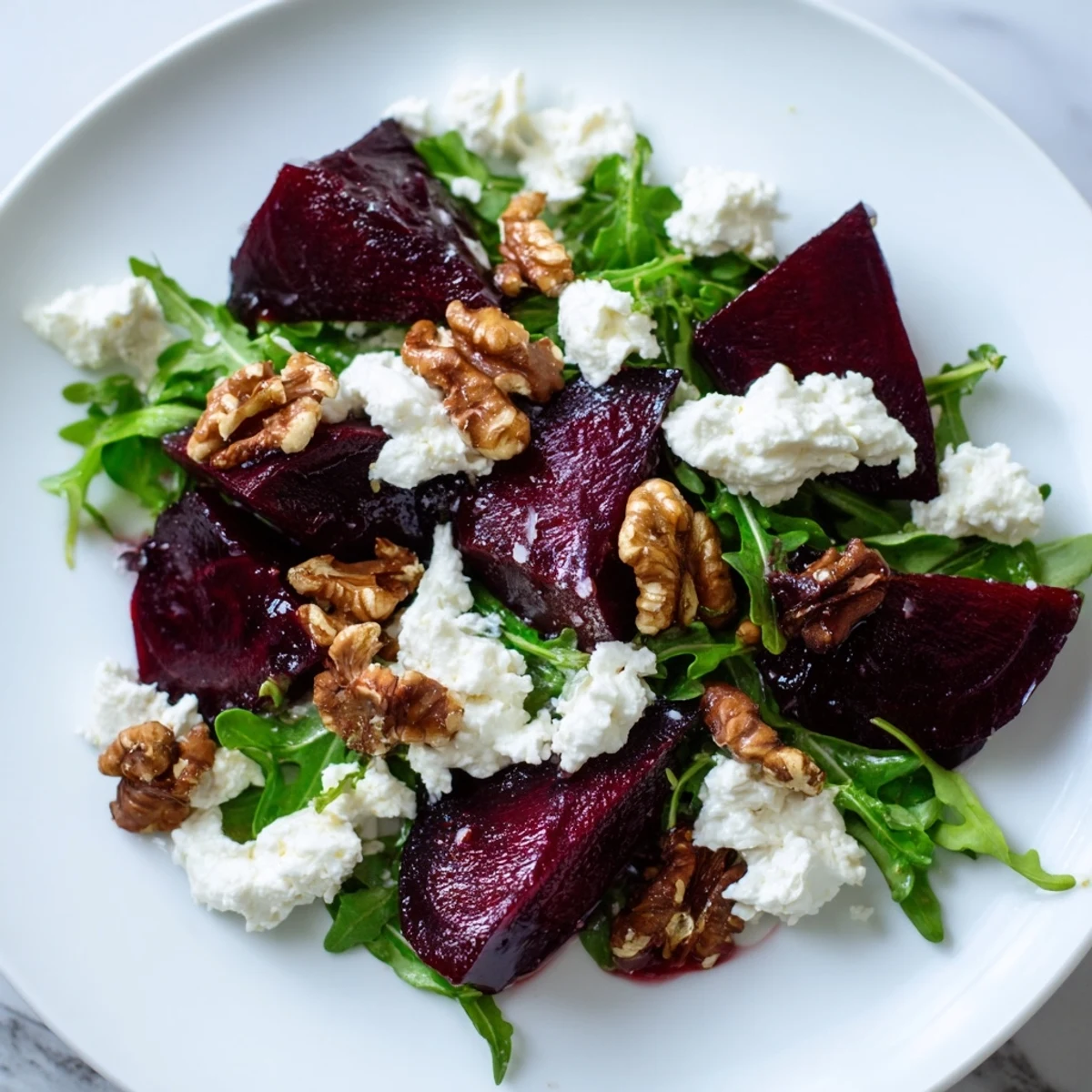 Close-up of a colorful Roasted Beet Walnut Salad with candied walnuts and arugula, ready to eat.