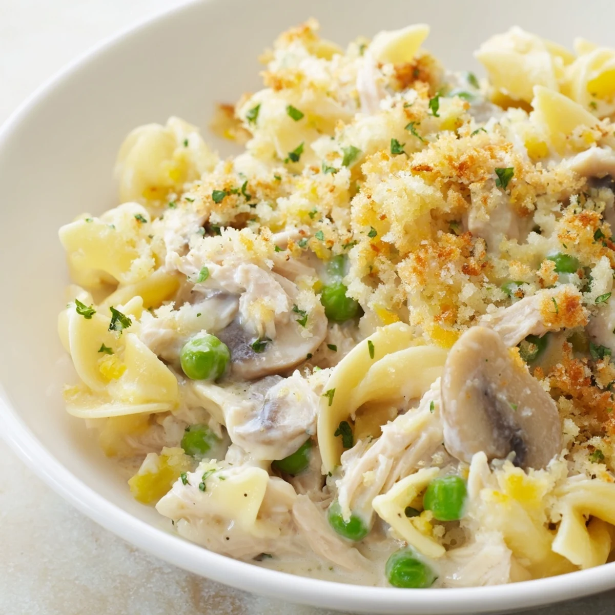 Golden-brown Tuna Noodle Casserole baking, with creamy sauce and crispy panko topping, ready to serve.