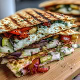 Mediterranean quesadilla wedges served with fresh herbs and creamy dipping sauce on the side. 