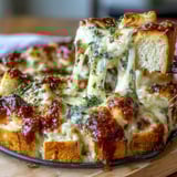 Melted cheese pulls away from hearty Cheesy Garlic Bread Lasagna Skillet beside fresh parsley and salad.
