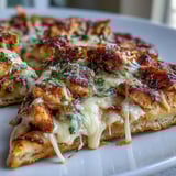 Freshly chopped romaine and shaved parmesan garnish the baked Garlic Naan Chicken Caesar Pizzas, drizzled with dressing.