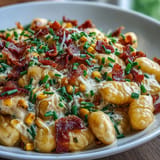 Cheesy gnocchi in a rich corn sauce, studded with savory bacon, ready to serve.