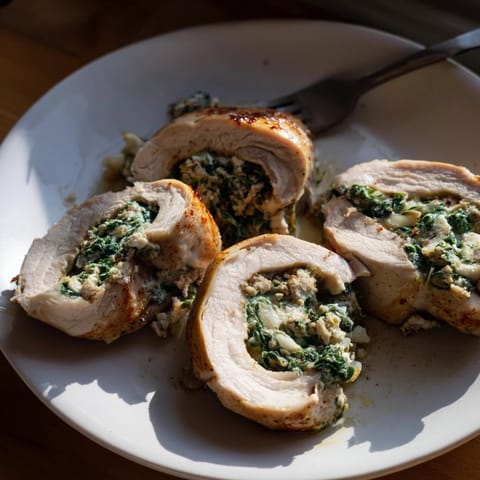 Savory feta and spinach stuffed chicken, resting on a bed of vibrant greens.  