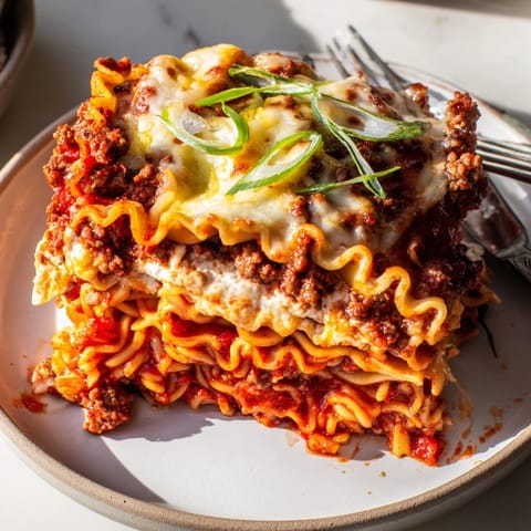 A warm and comforting Spicy Ramen Lasagna topped with bubbling mozzarella and savory meat sauce.  