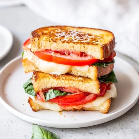 Crispy Air Fryer Pizza Margherita Grilled Cheese brimming with tomatoes, flavorful pizza sauce, and gooey cheese.