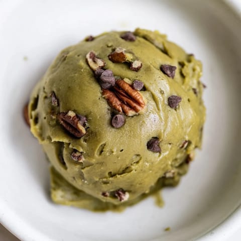 These vibrant, green Matcha Gingerbread Cookie Dough Protein Bites await refrigeration, promising a flavorful, energizing treat.