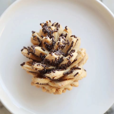 A close-up of textured Pinecone Shaped Peanut Butter Cookies, arranged beautifully on a holiday platter.