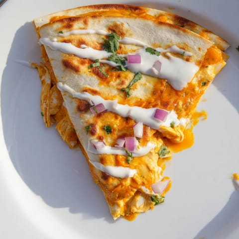 A close-up of a delicious Buffalo Chicken Quesadilla, featuring crispy edges and savory chicken inside.