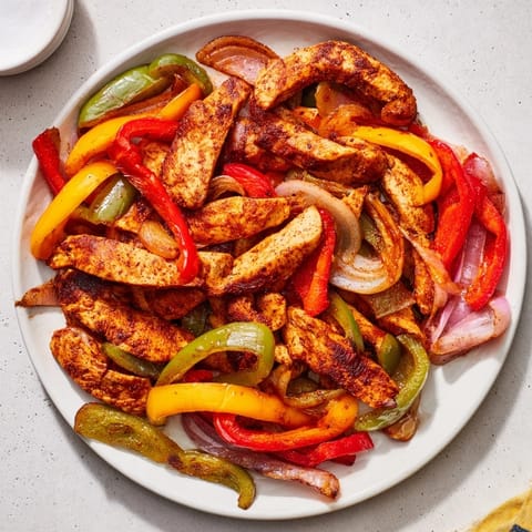 Sheet pan Chicken Fajitas reveal tender chicken strips with perfectly roasted vegetables, ready for serving.