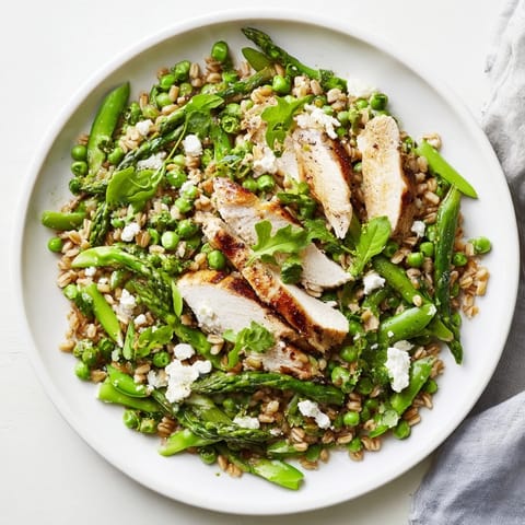 Bright lemon vinaigrette coats the wholesome Warm Spring Farro Chicken Salad with peas and arugula.  
