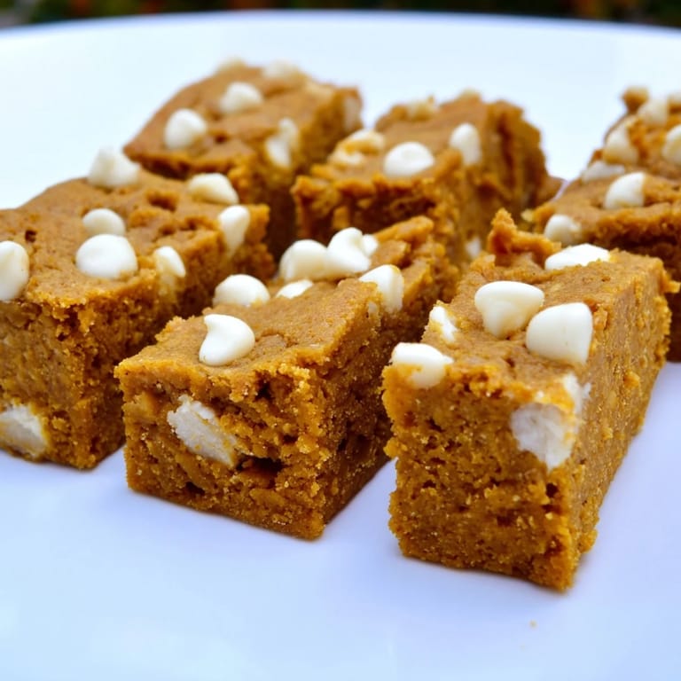 Delicious pumpkin muffin bars filled with creamy white chocolate chips, ideal for sharing with friends.