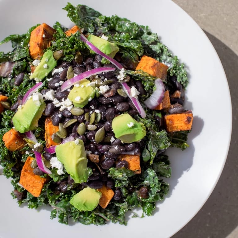 Enjoy this hearty massaged kale salad, combining sweet potatoes, black beans, and a zesty dressing.